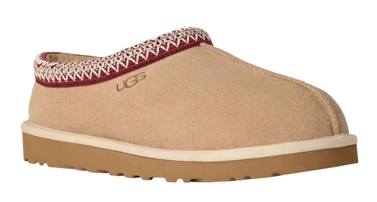 Tan UGG slipper with a patterned tongue on a white background