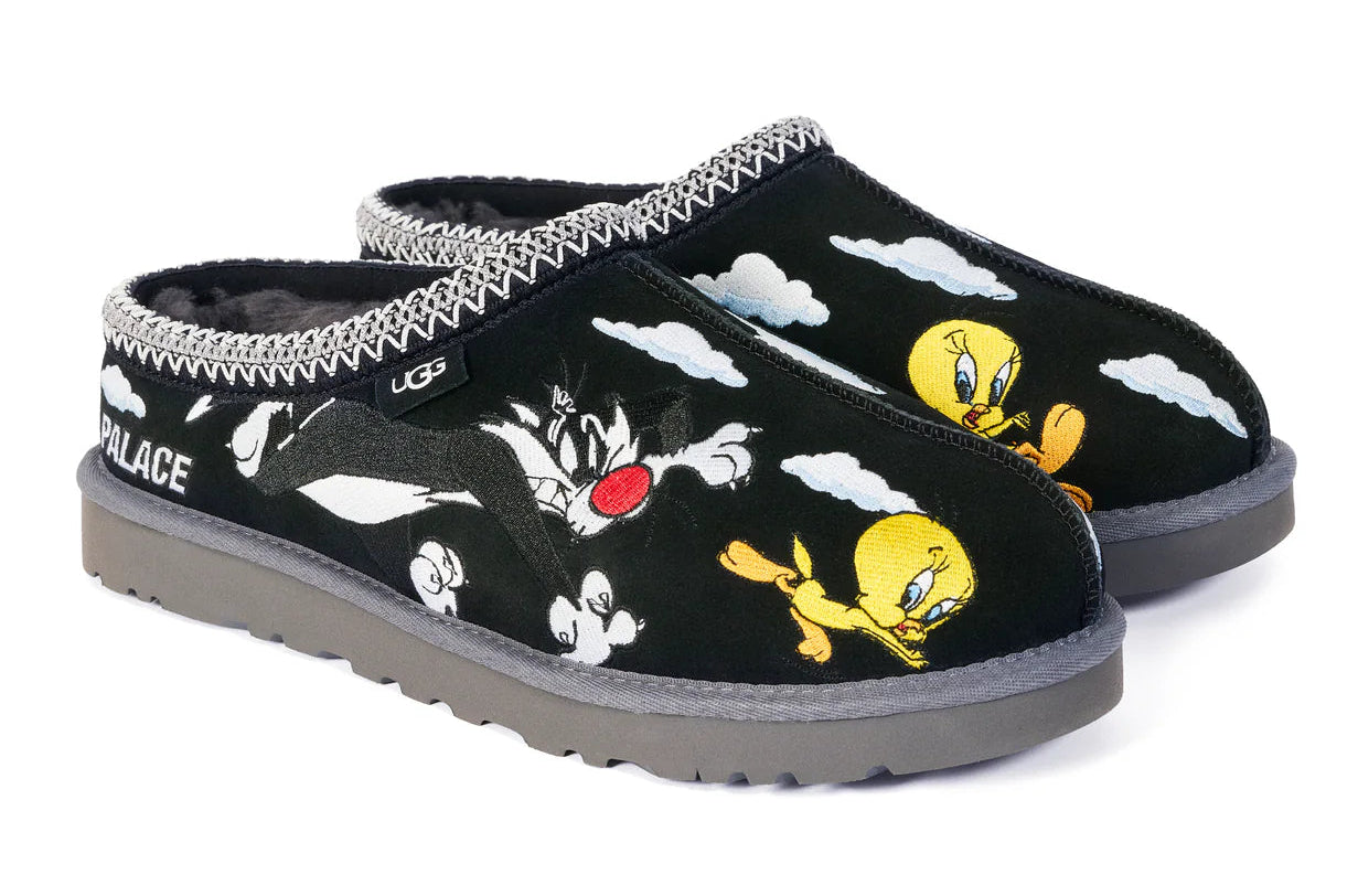 Pair of black slippers with cartoon character design on a white background
