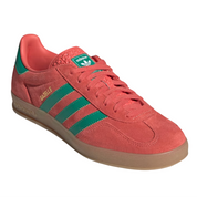 Red Adidas sneaker with green stripes on a white background