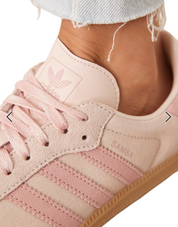 Pink Adidas sneaker with white laces and sole on a white background