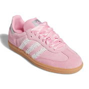 Pink Adidas sneaker with white stripes on a white background