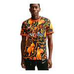 Person wearing a black and orange patterned sports jersey with visible branding on a white background - Image 1